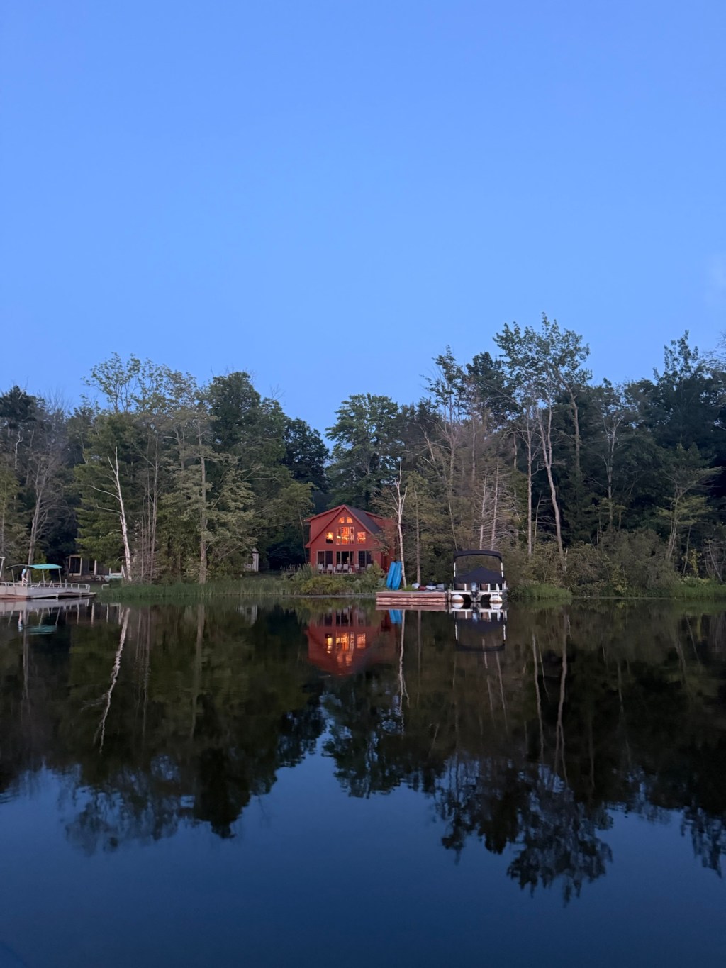 Sand bottom lake with blue skies and clear water, trees surround this forested private lake.